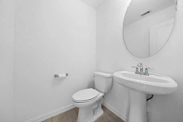 bathroom featuring hardwood / wood-style flooring and toilet