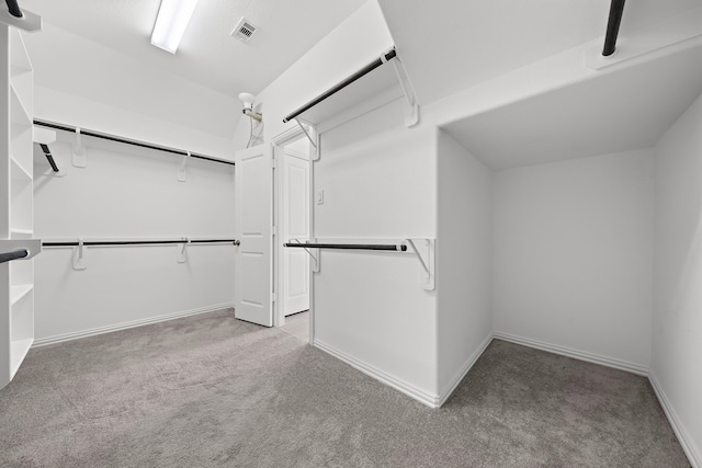 walk in closet featuring light carpet