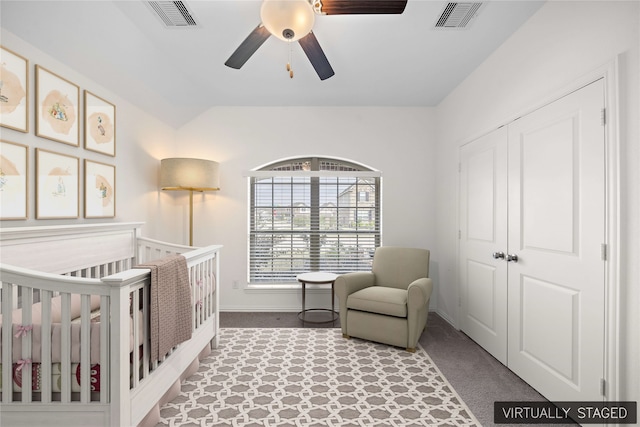 carpeted bedroom featuring a closet, a nursery area, and ceiling fan