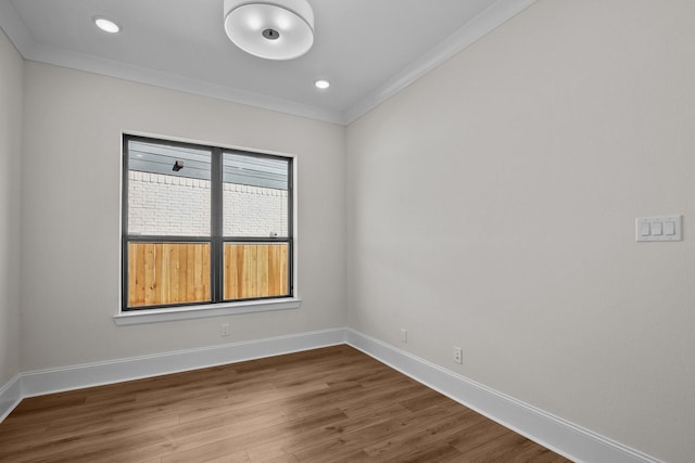 spare room with ornamental molding and hardwood / wood-style floors