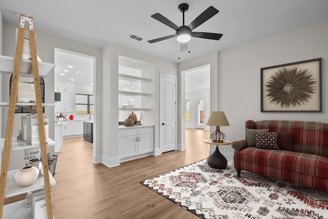 living room with ceiling fan and light wood-type flooring