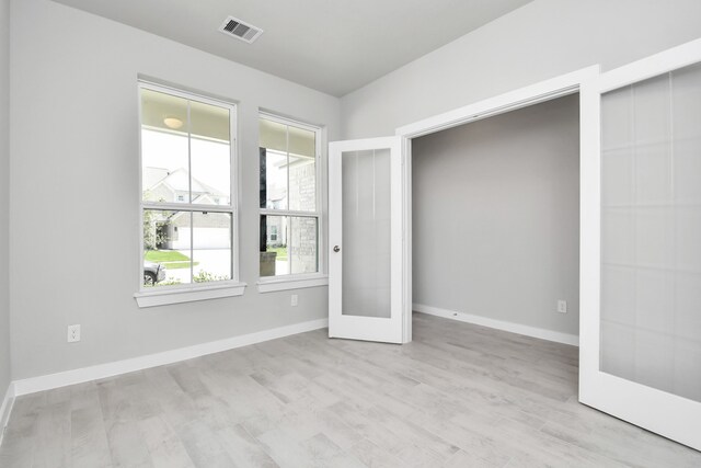 unfurnished bedroom with light wood-type flooring and french doors