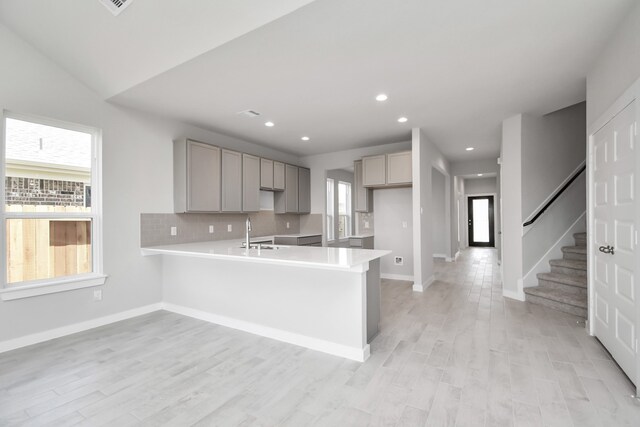 kitchen featuring kitchen peninsula, plenty of natural light, and gray cabinetry