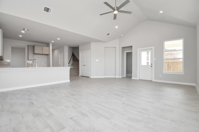 unfurnished living room featuring ceiling fan, sink, high vaulted ceiling, and light hardwood / wood-style floors