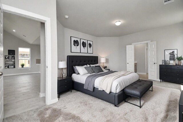 bedroom featuring lofted ceiling and light hardwood / wood-style flooring