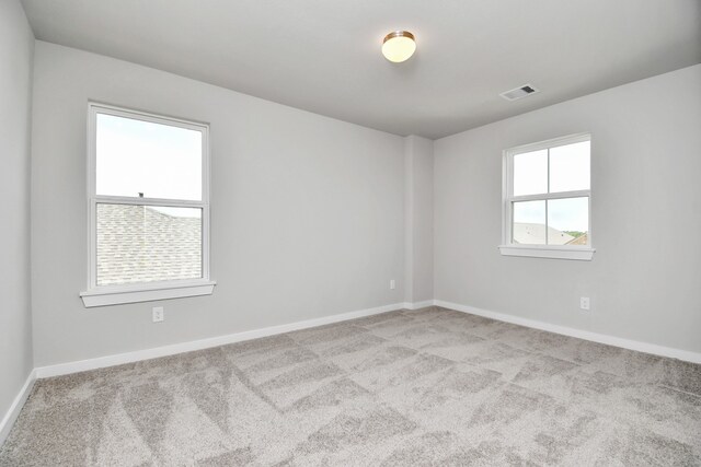 unfurnished room with light carpet and plenty of natural light