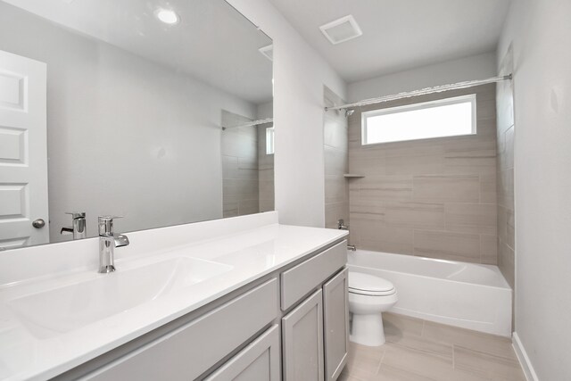 full bathroom featuring tiled shower / bath combo, toilet, and vanity