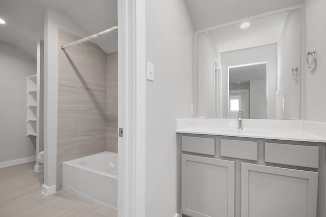 full bathroom featuring vanity, tiled shower / bath combo, and toilet