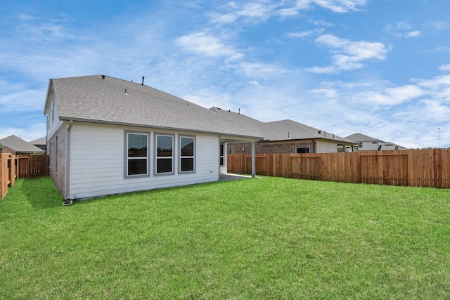 rear view of property featuring a lawn