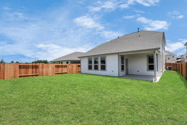 back of property featuring a lawn, cooling unit, and a patio