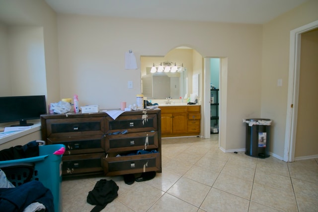 bedroom featuring light tile patterned floors, connected bathroom, and sink