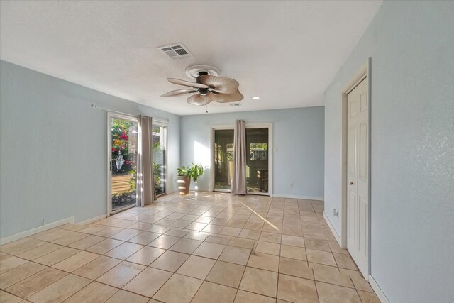 tiled empty room featuring ceiling fan