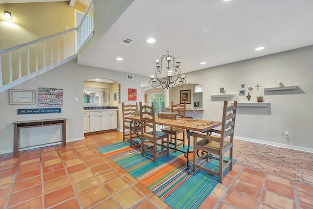 tiled dining room with a chandelier