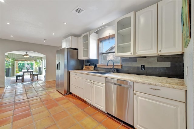 kitchen featuring stainless steel appliances, white cabinetry, plenty of natural light, and ceiling fan