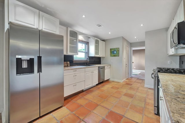 kitchen with light stone countertops, white cabinetry, and appliances with stainless steel finishes