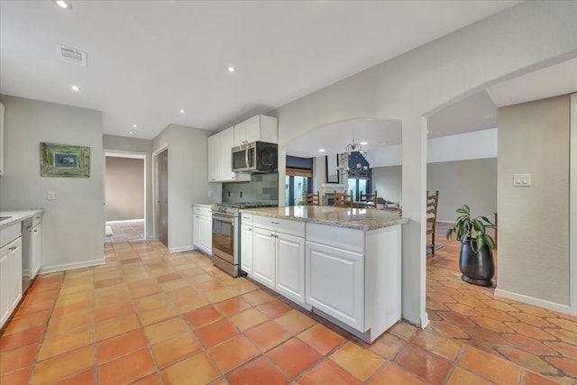 kitchen with light stone countertops, white cabinets, light tile patterned floors, and appliances with stainless steel finishes