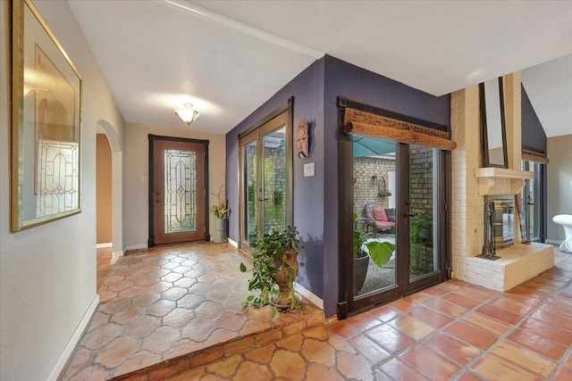 foyer entrance featuring a brick fireplace