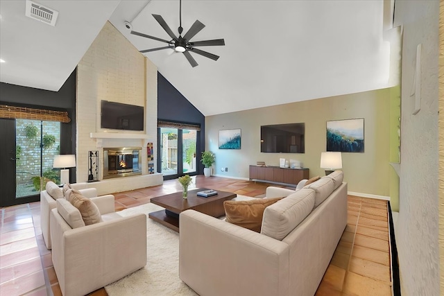 living room with ceiling fan, a large fireplace, high vaulted ceiling, and light tile patterned flooring