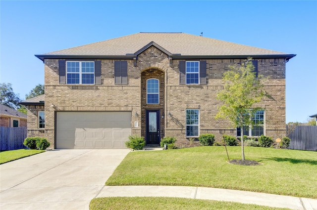 traditional-style home featuring fence, driveway, a front lawn, a garage, and brick siding