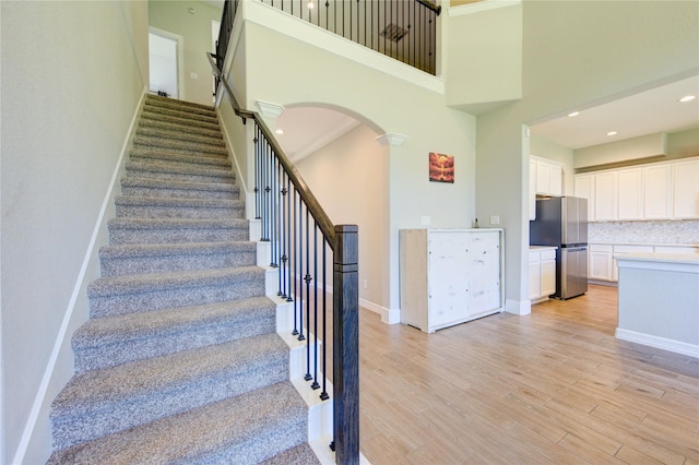 stairway featuring a high ceiling and hardwood / wood-style floors