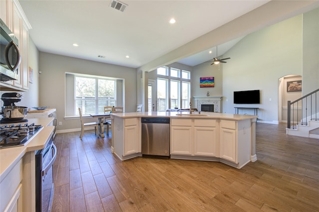 kitchen featuring a kitchen island, white cabinets, stainless steel appliances, and light hardwood / wood-style floors