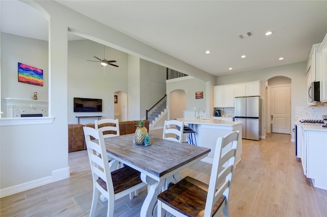 dining space featuring ceiling fan, sink, and light hardwood / wood-style flooring