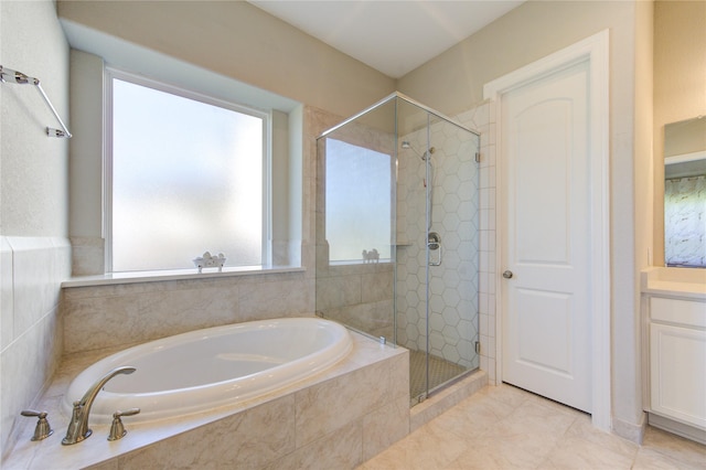 bathroom featuring plus walk in shower, vanity, and tile patterned floors