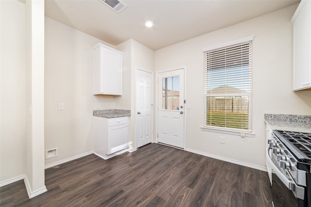 kitchen featuring stainless steel gas range oven, light stone counters, dark hardwood / wood-style flooring, and white cabinets