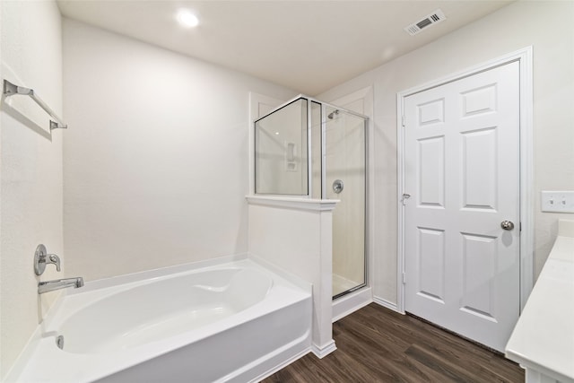 bathroom featuring hardwood / wood-style floors and plus walk in shower