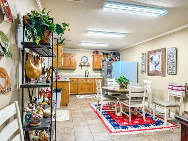 kitchen with stainless steel fridge with ice dispenser, white refrigerator, ornamental molding, and sink