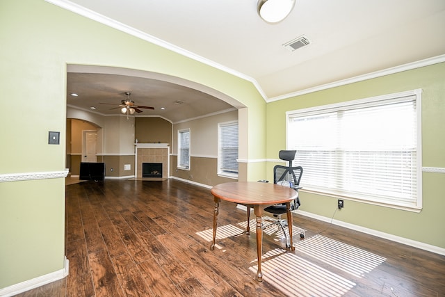 home office with ceiling fan, crown molding, a tile fireplace, dark hardwood / wood-style floors, and lofted ceiling