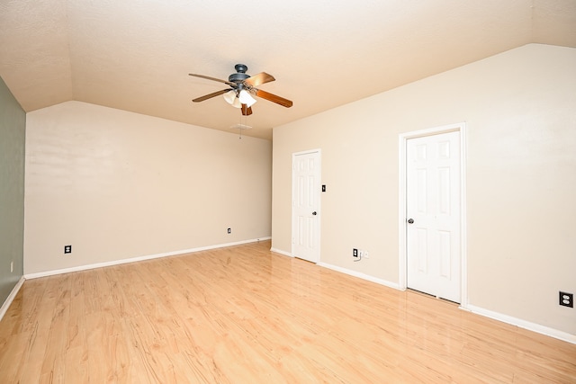 empty room with light wood-type flooring and lofted ceiling