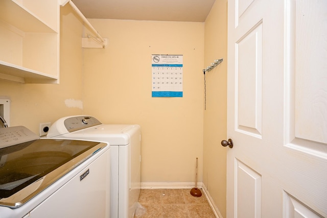 washroom with light tile patterned floors and washing machine and dryer