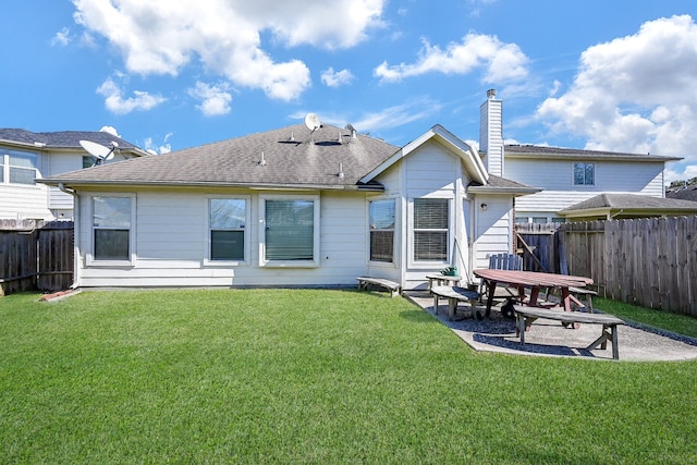 rear view of property with a yard and a patio