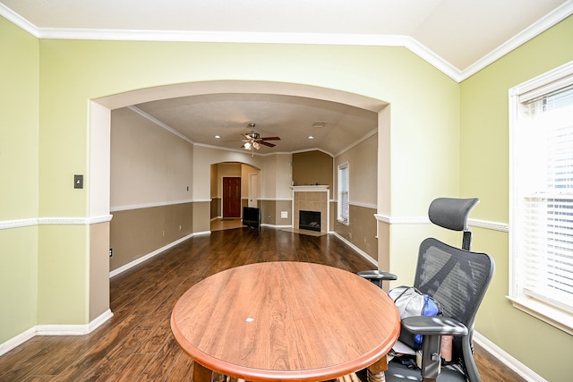 office with dark hardwood / wood-style flooring, ornamental molding, ceiling fan, lofted ceiling, and a tiled fireplace