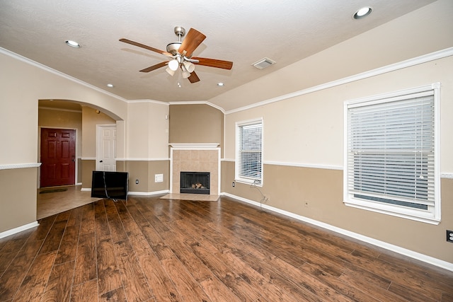 unfurnished living room with a textured ceiling, ceiling fan, crown molding, a fireplace, and hardwood / wood-style floors