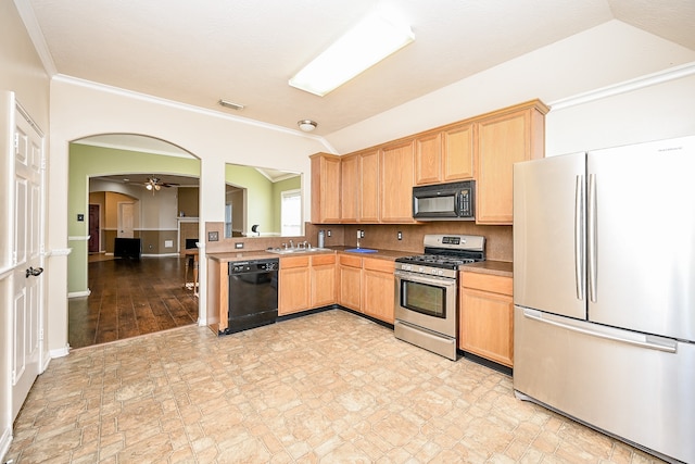 kitchen with black appliances, ornamental molding, sink, and vaulted ceiling