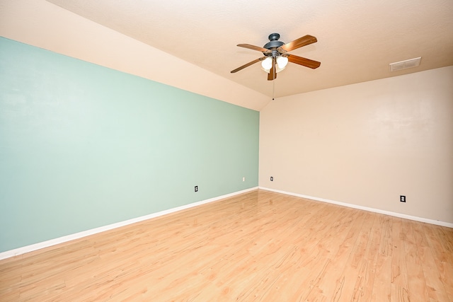 unfurnished room with ceiling fan, light wood-type flooring, a textured ceiling, and lofted ceiling