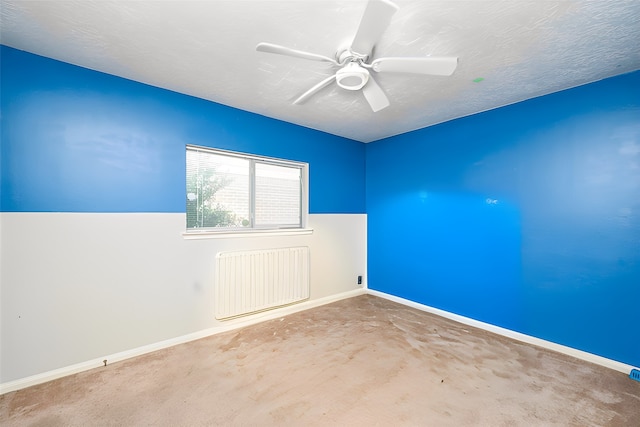 unfurnished room with ceiling fan, radiator heating unit, carpet floors, and a textured ceiling