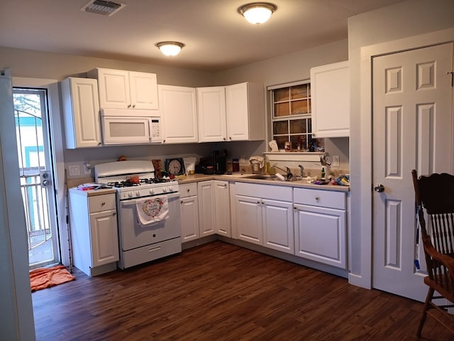 kitchen featuring dark hardwood / wood-style flooring, white appliances, white cabinetry, and sink