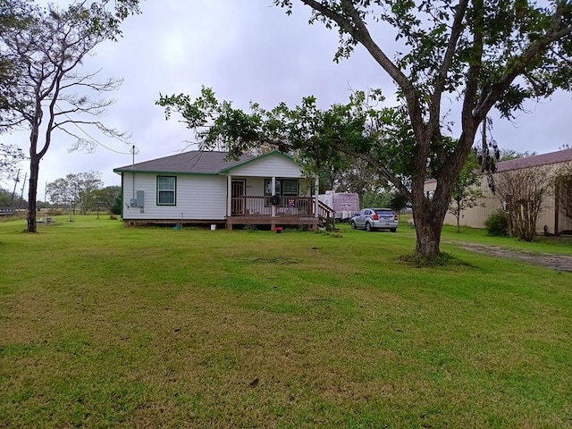 rear view of property featuring a lawn and a wooden deck