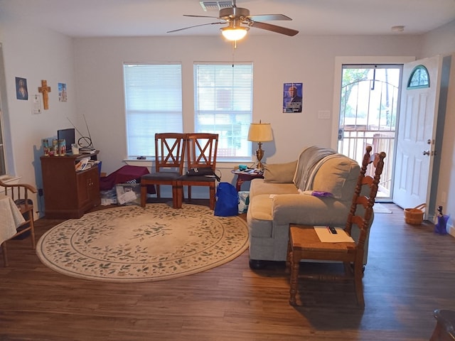 living room featuring ceiling fan and dark wood-type flooring