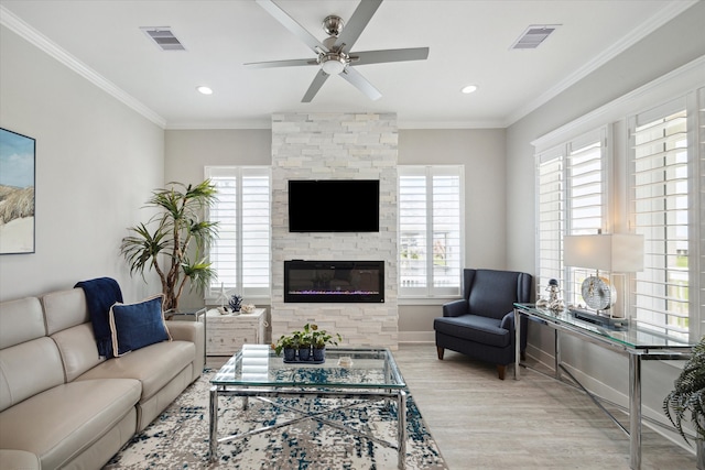 living room with a healthy amount of sunlight, light hardwood / wood-style floors, and ornamental molding