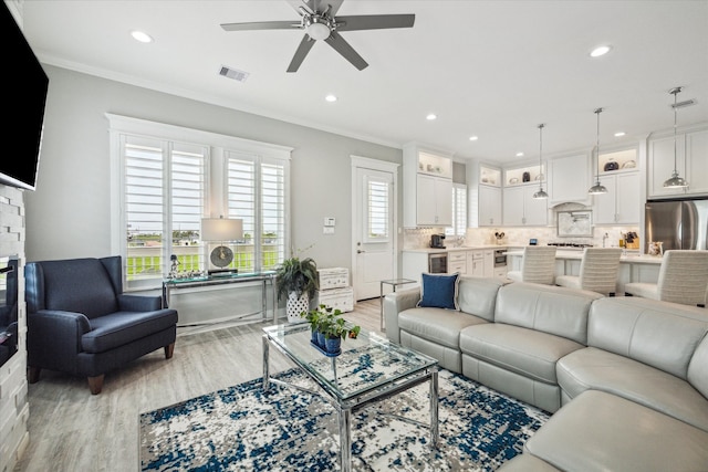 living room featuring ceiling fan, light wood-type flooring, ornamental molding, and wine cooler