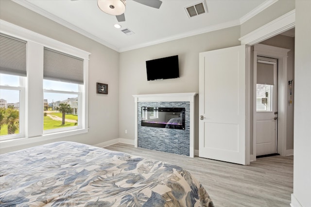 bedroom with ceiling fan, ornamental molding, and light wood-type flooring