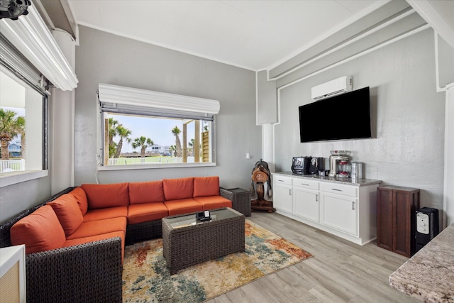 living room with light hardwood / wood-style floors and an AC wall unit