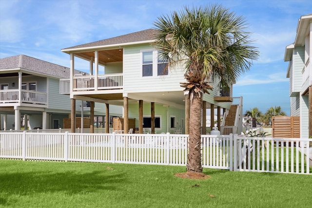 view of front of property featuring a front yard and a balcony