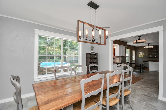 dining space featuring ornamental molding, a notable chandelier, and hardwood / wood-style flooring