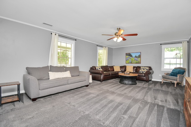 carpeted living room featuring a wealth of natural light, crown molding, and ceiling fan