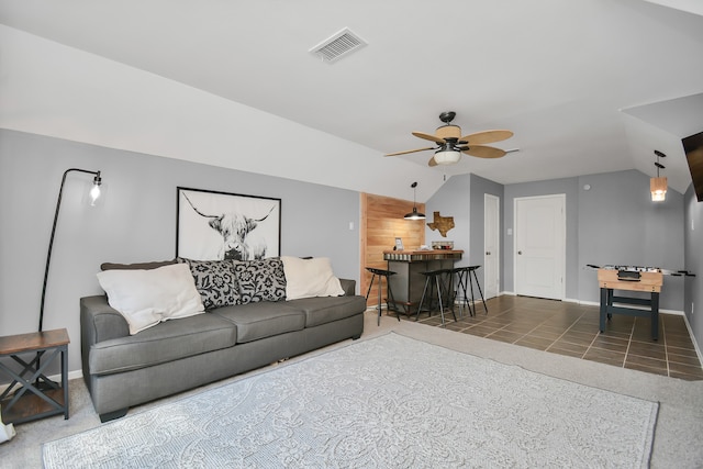 tiled living room with ceiling fan and vaulted ceiling